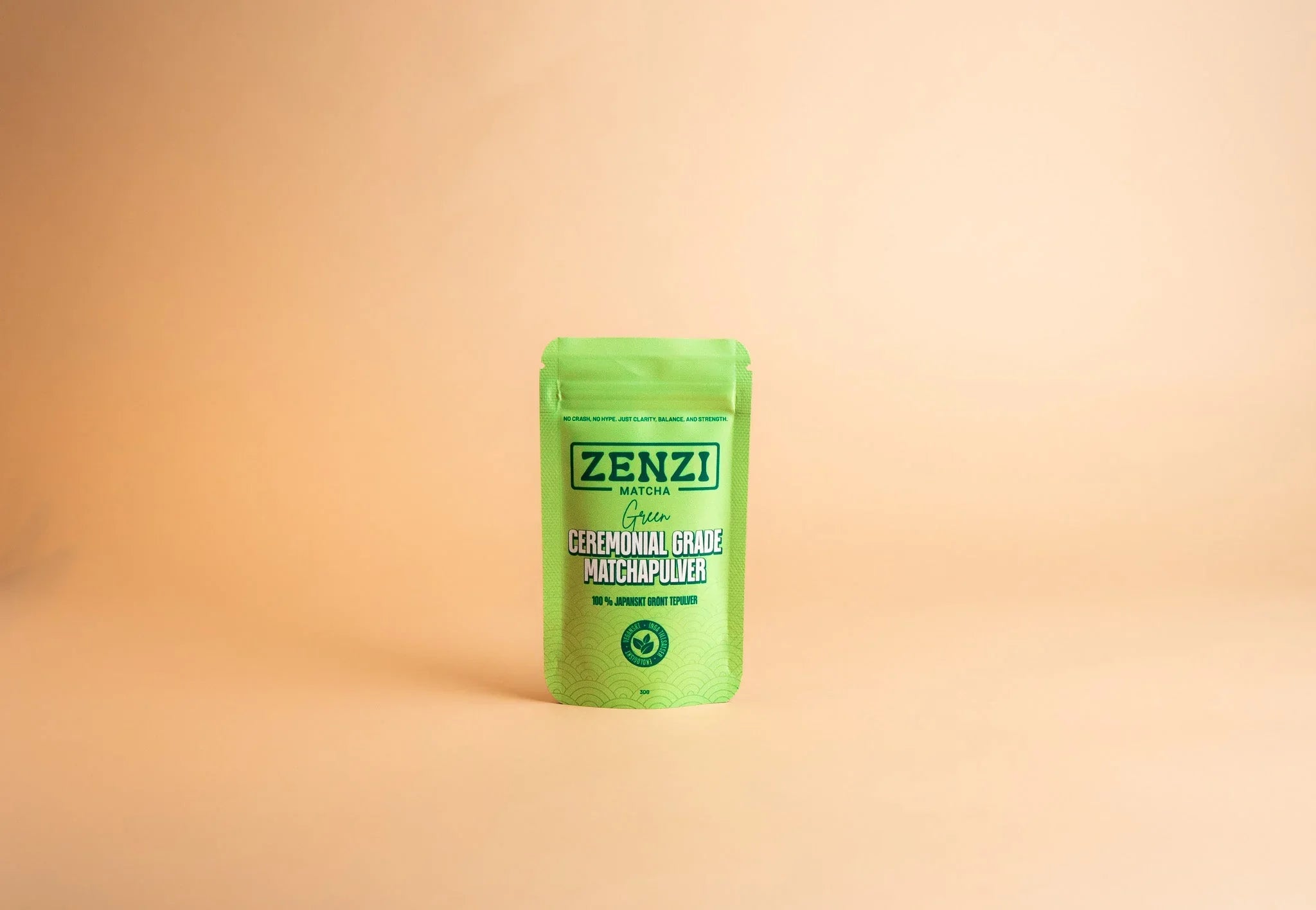 Green ceremonial grade matcha powder pouch on light beige background