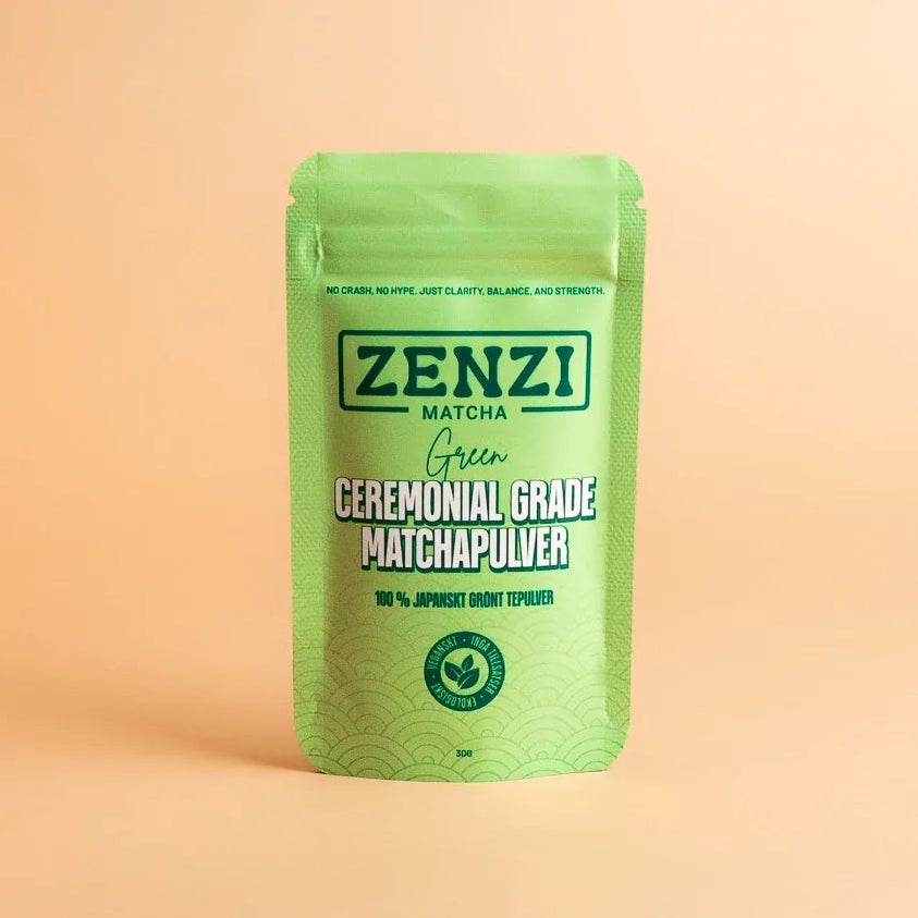 Green ceremonial grade matcha powder pouch on a beige background