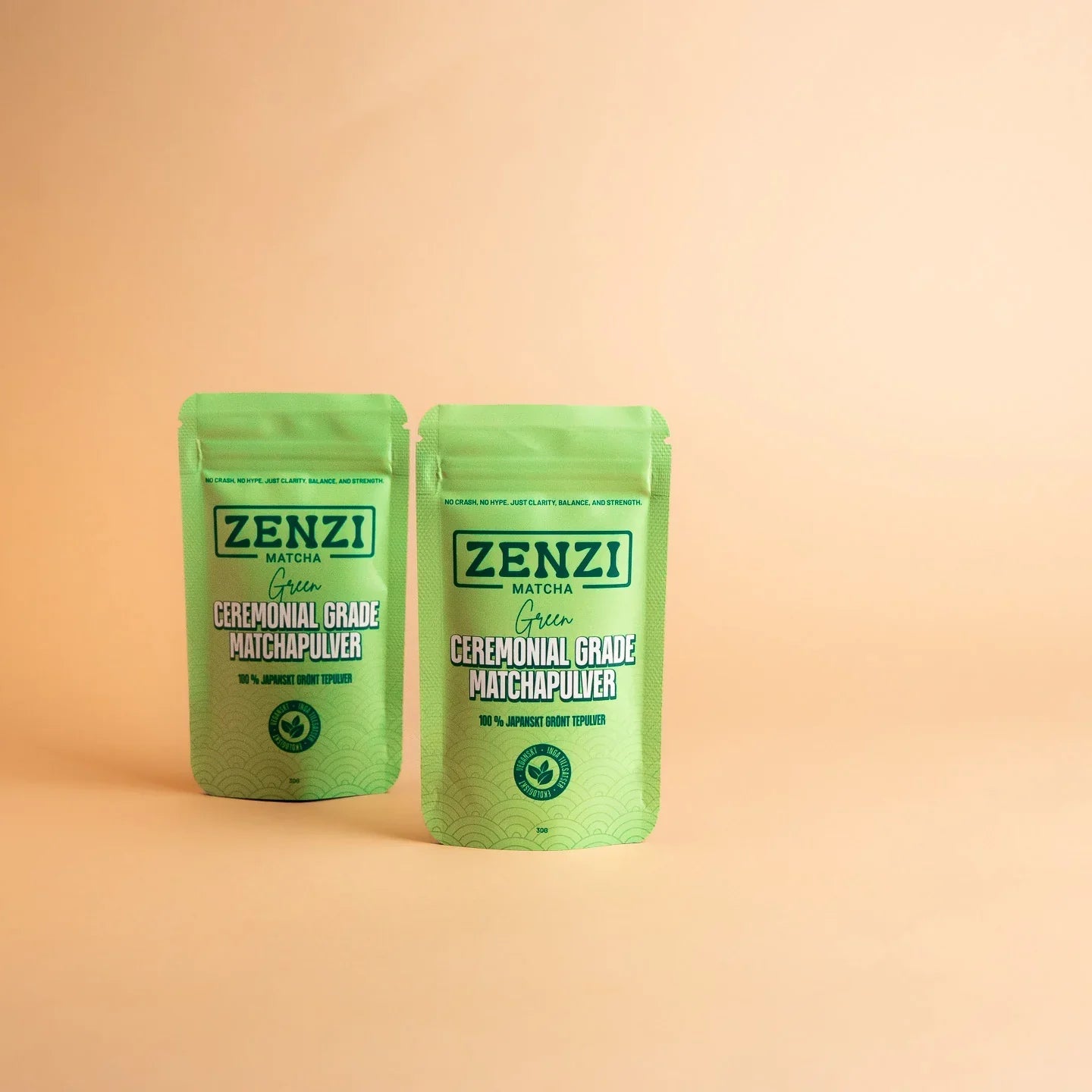 Two green pouches of ceremonial grade matcha powder on a beige background